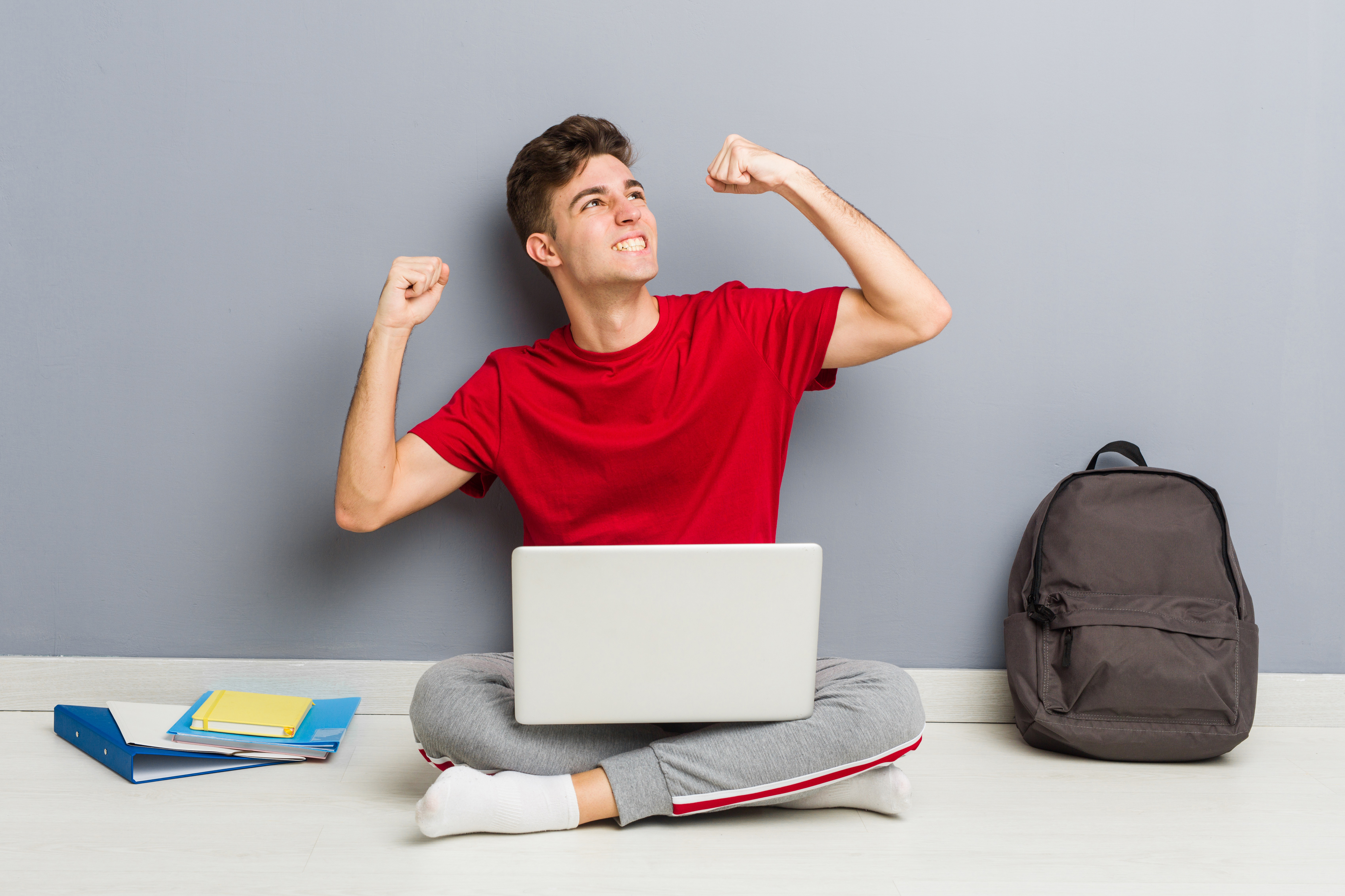 young-student-man-sitting-his-house-floor-holding-laptop